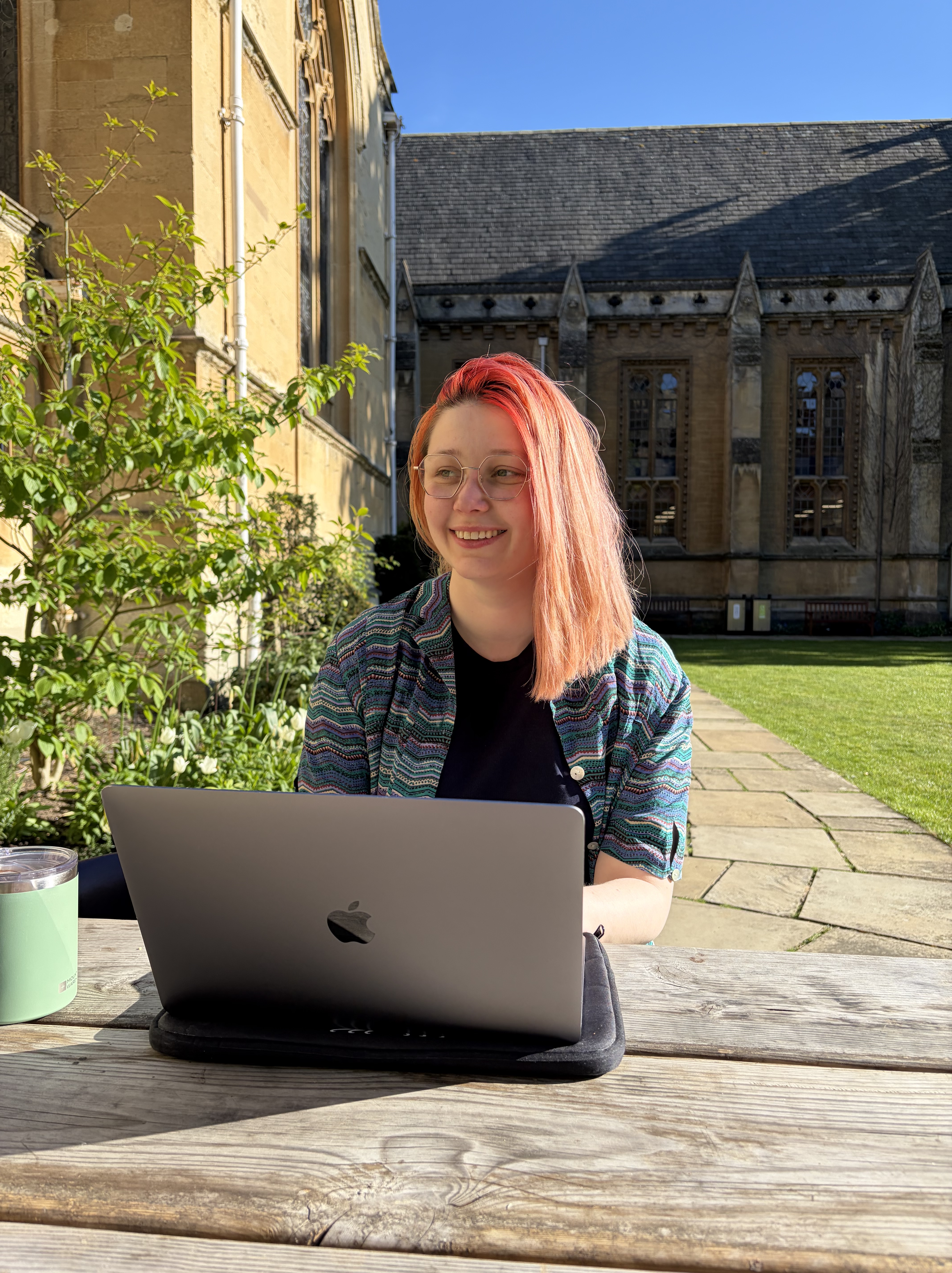 Rowan working on a laptop in the college gardens